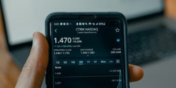 a person holding a cell phone in front of a laptop