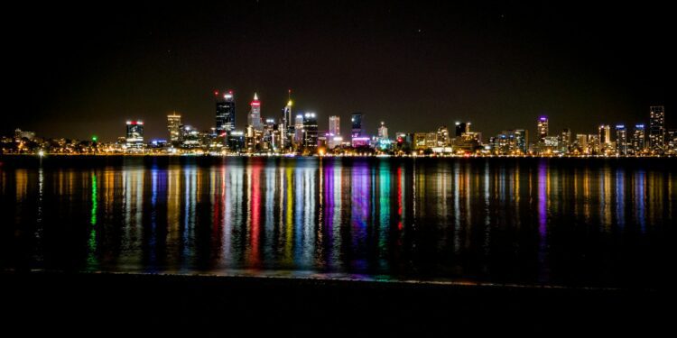 city lights reflecting on harbor at nighttime