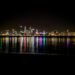 city lights reflecting on harbor at nighttime