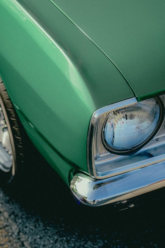 Green classic car headlight detail.
