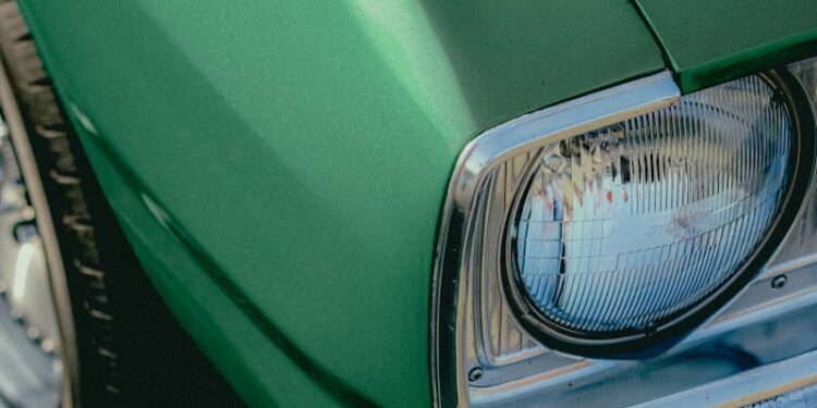Green classic car headlight detail.