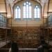 Grand library interior with tall bookshelves and arched windows