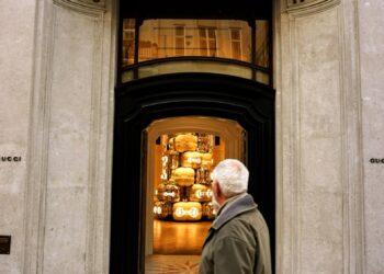 A man walking past a gucci store