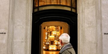 A man walking past a gucci store