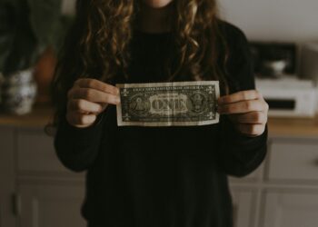 girl holding 1 U.S. dollar banknote