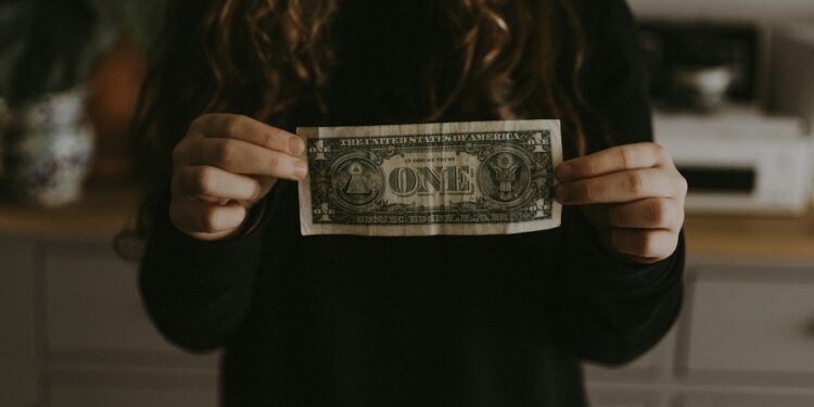 girl holding 1 U.S. dollar banknote