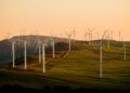 windmills on green field under white sky during daytime