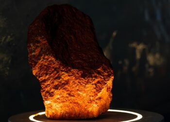 A stone is illuminated on a round pedestal.